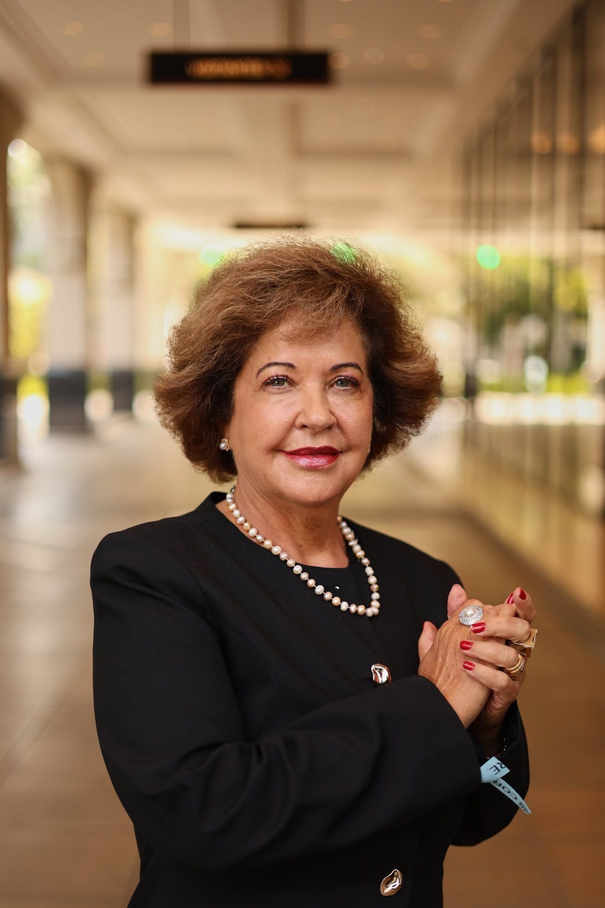 Dra. Miriam Mantovani em pé, de blazer escuro